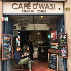 Entrance to Cafe D'Wasi with chalkboards and person sitting in chair