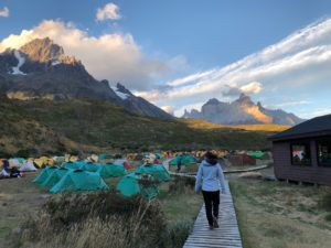 Campground in front of mountain with woman walking through